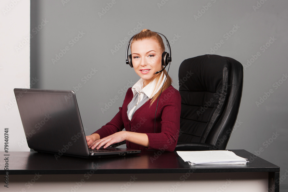 businesswoman talking by the phone while working on her computer businesswoman talking by the phone while working on her computer
