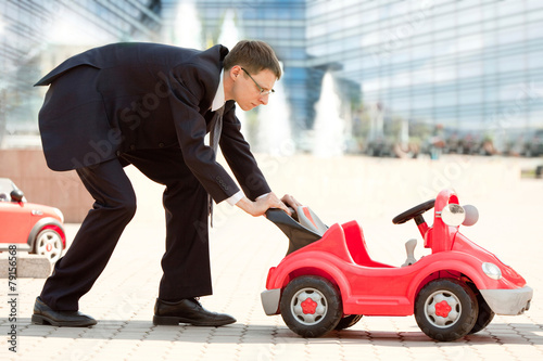 Businessman and Toy Red Car © AlexanderNovikov