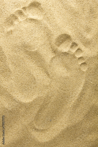 Two footprints in sand at the beach