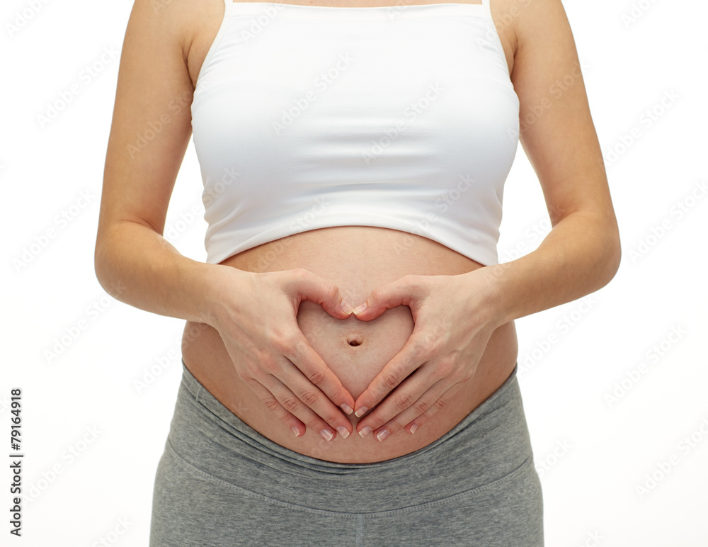 close up of pregnant woman touching her bare tummy close up of pregnant woman touching her bare tummy