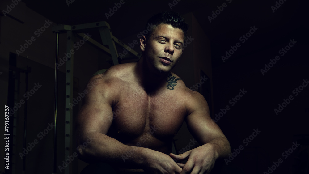 Fototapeta premium Young bodybuilder posing in a gym