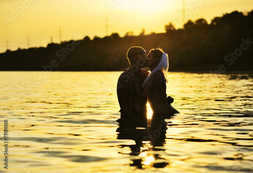 couple kissing in the water at sunsetcoupl