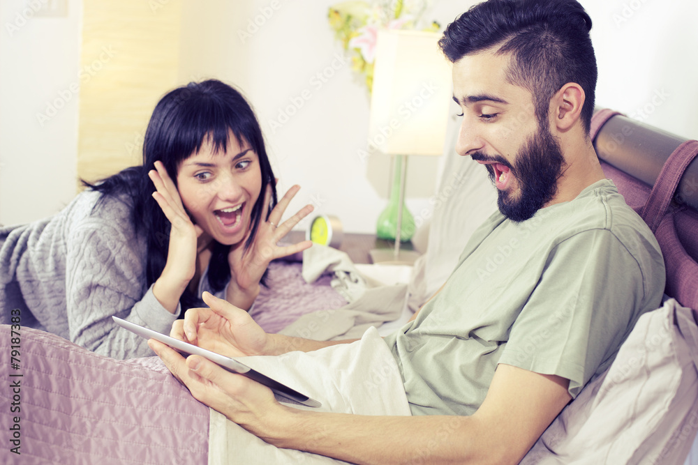 Surprised couple having won game online with tablet Surprised couple having won game online with tablet