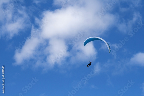 Paragliding in the blue sky with skis