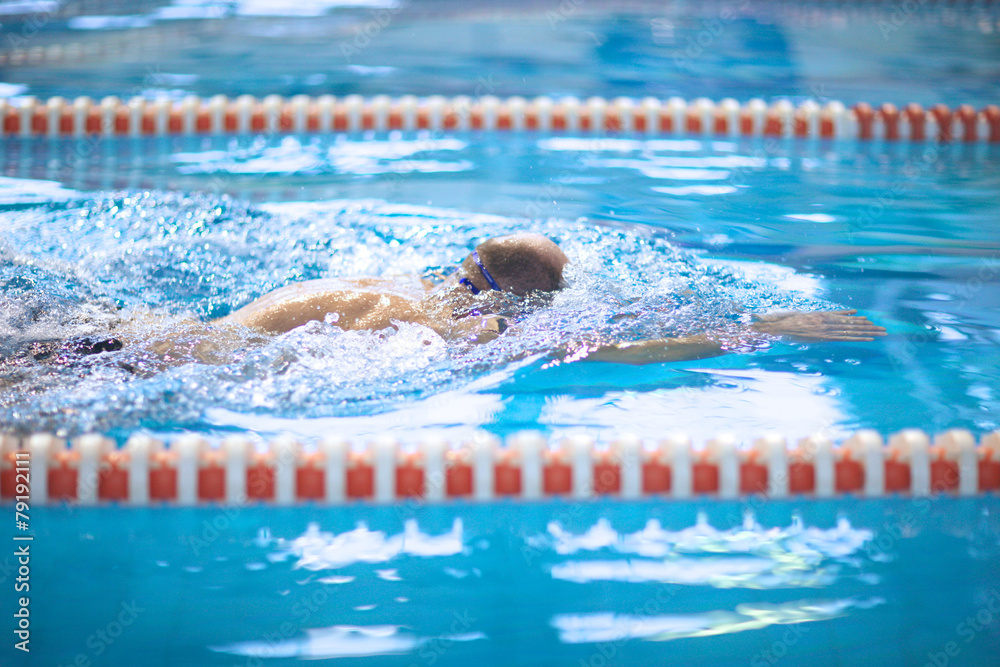 Side view of man swimming in freestyle