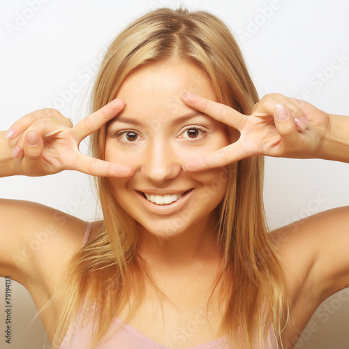 Happy smiling beautiful young woman showing two fingers or victo photo