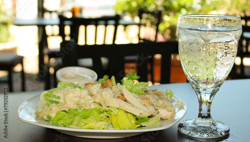 Chicken caesar salad with a glass of iced water