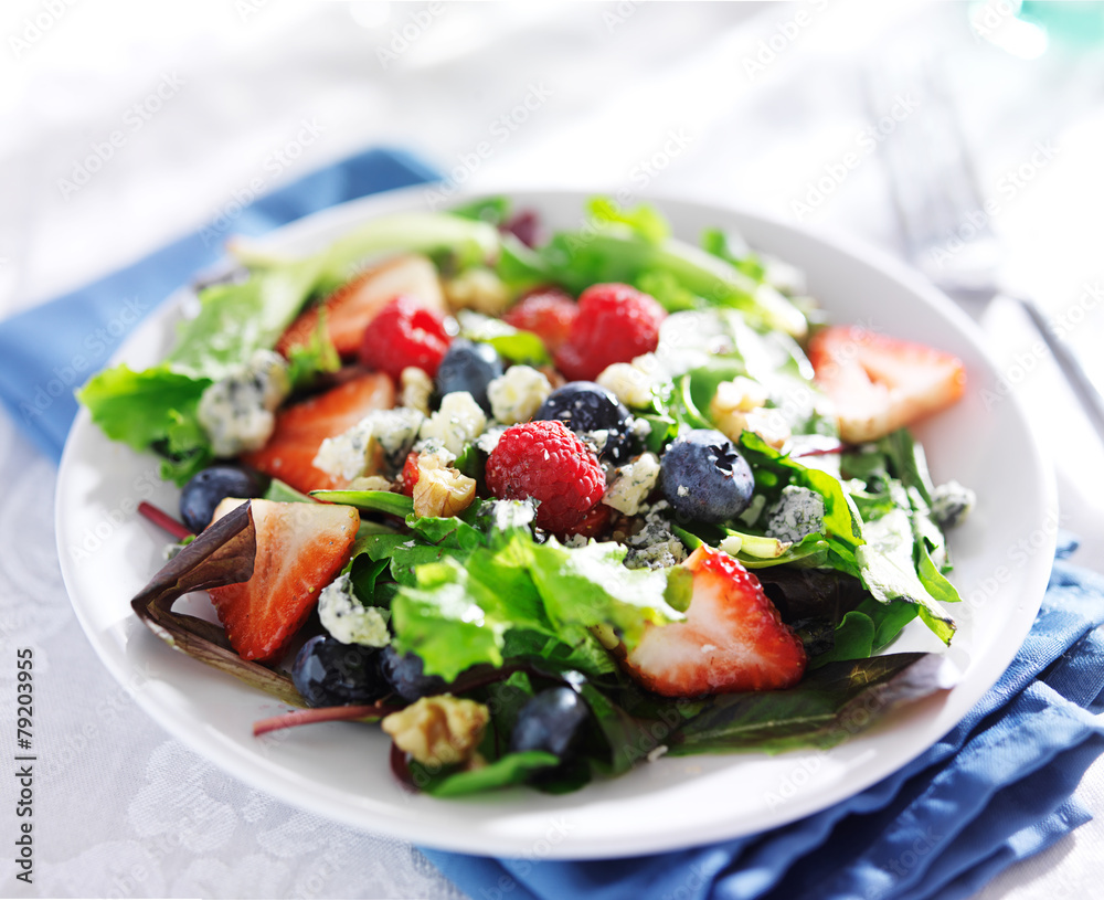 berry salad with walnuts and blue cheese on white table cloth