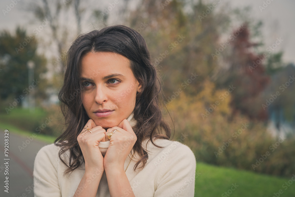 Beautiful young woman posing in a city park