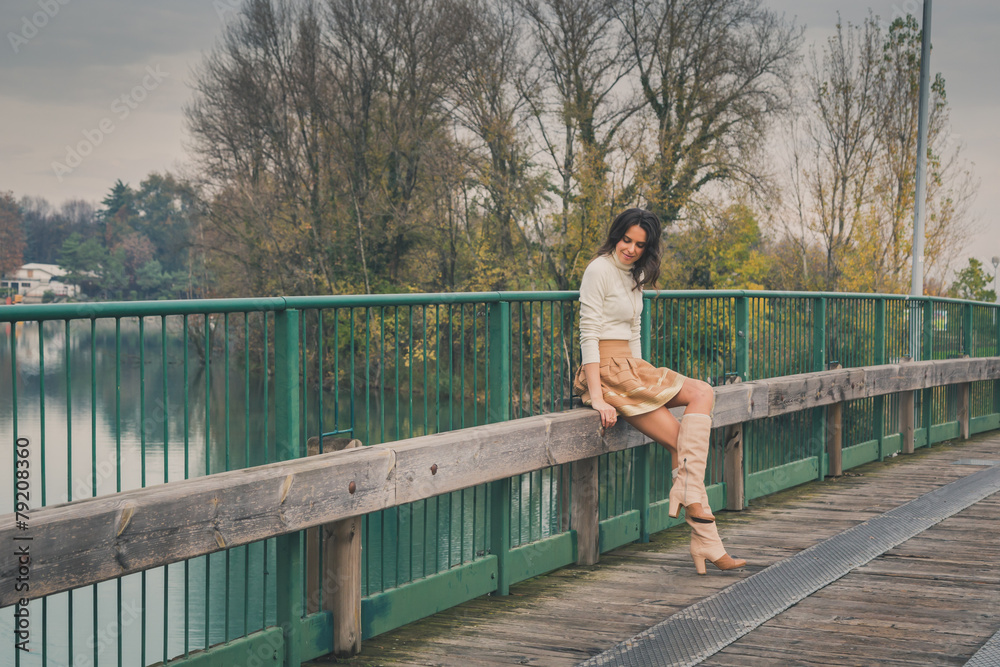 Beautiful young woman posing on a bridge