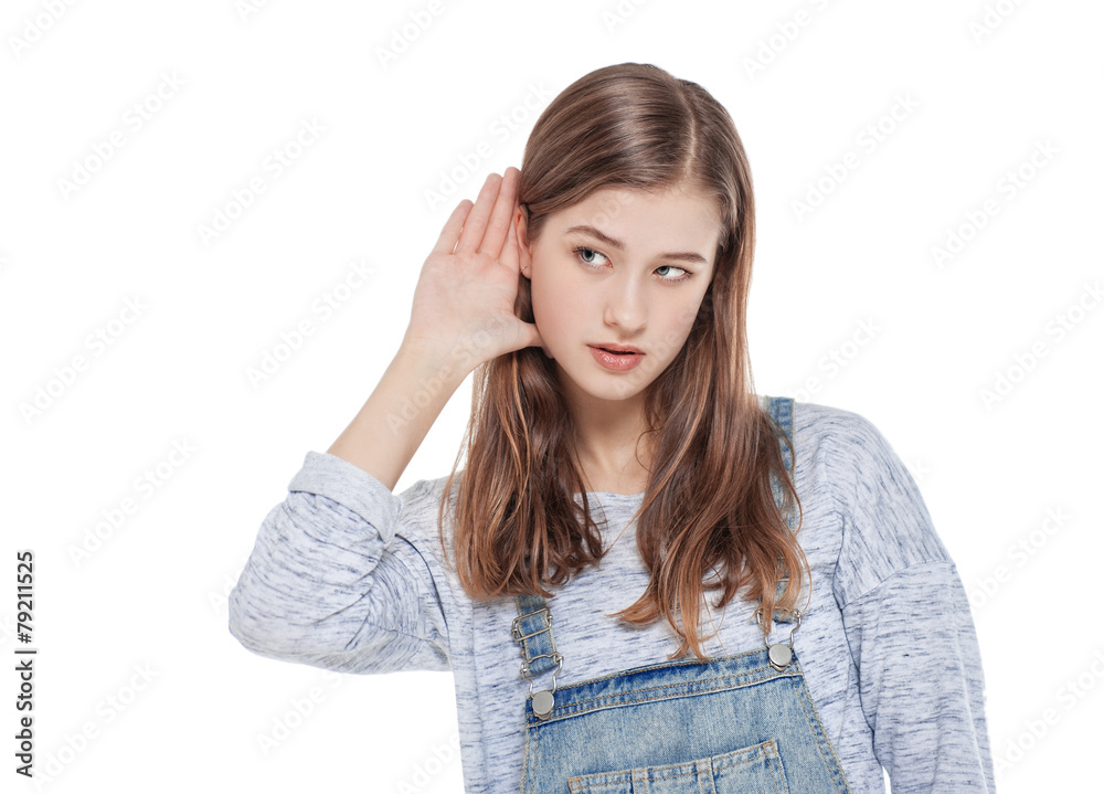 Young teenage fashion girl holds his hand near his ear and liste Young teenage fashion girl holds his hand near his ear and liste
