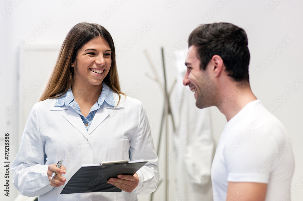 Doctor visiting her male patient and taking notes at office. Doctor visiting her male patient and taking notes at office.