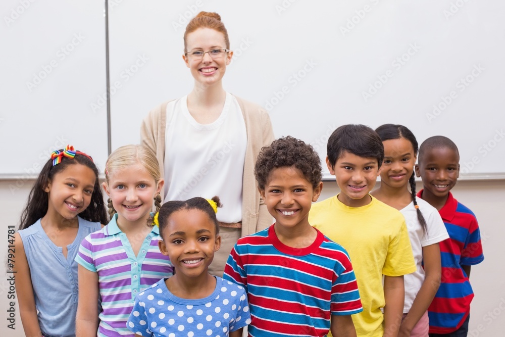 Obraz premium Teacher and pupils smiling at camera in classroom