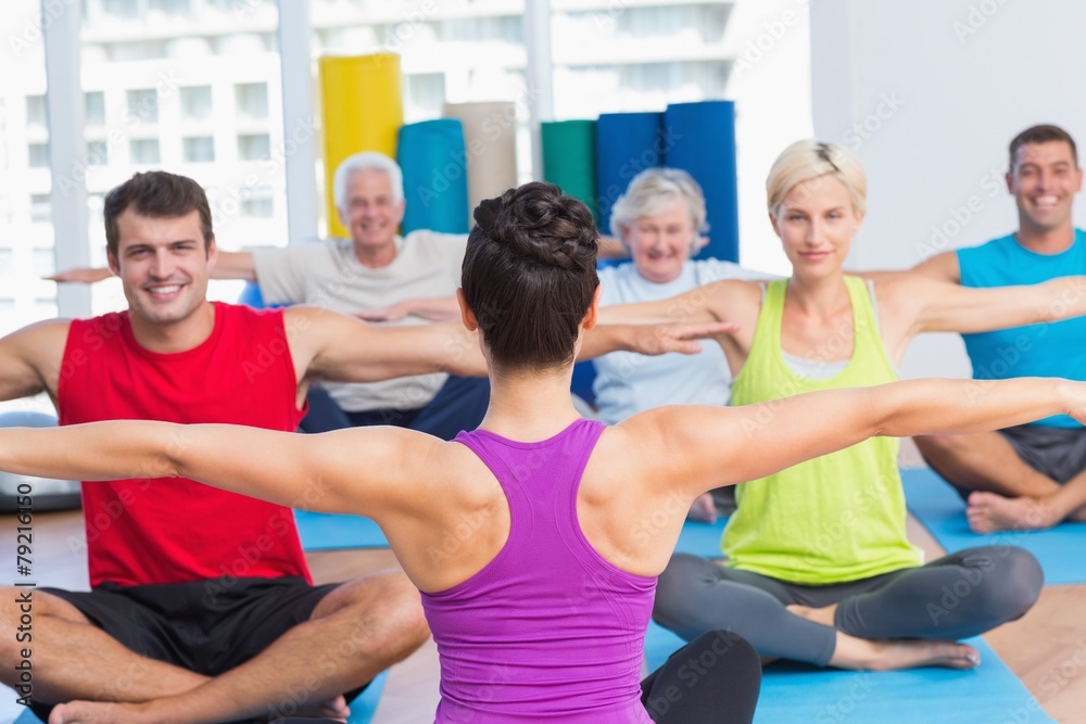 People practicing yoga in health club