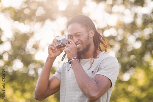 Handsome hipster using vintage camera