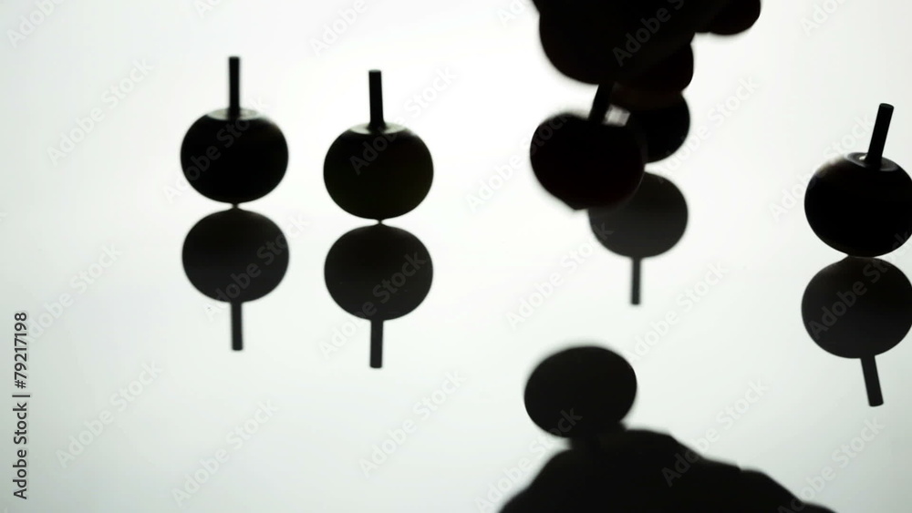 Spinning spin tops on white surface - back lit Spinning spin tops on white surface - back lit