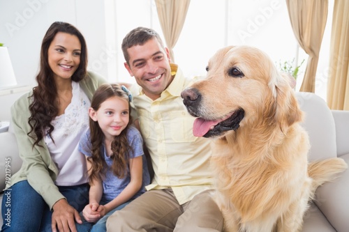 Family sitting with Golden Retriever on sofa