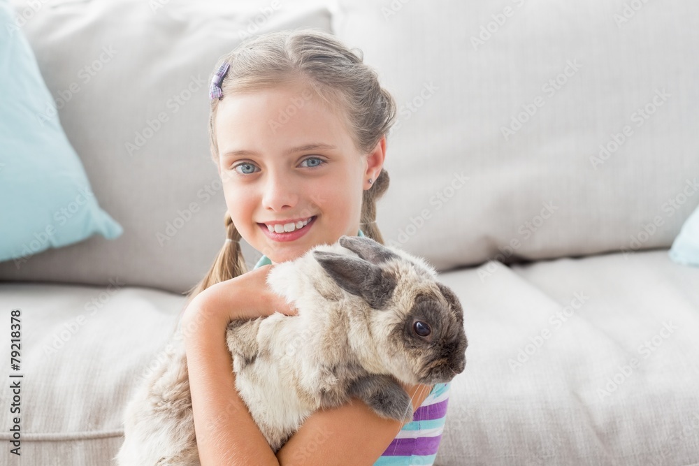 Happy girl holding rabbit in living room Happy girl holding rabbit in living room
