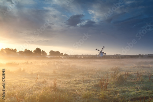 windmill in summer mist at sunrise