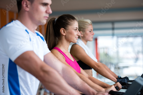 friends exercising on a treadmill at the bright modern gym