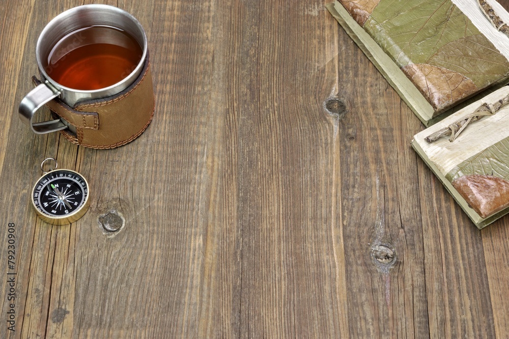 Fototapeta premium Compass, Tea Mug and Two Notebooks on Wood Table