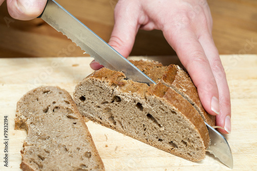 A hand cutting rye bread
