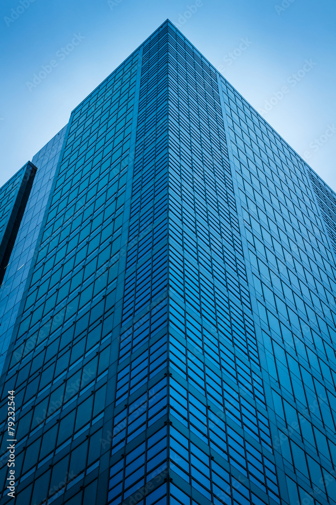 Fototapeta premium Skyscrapers from ground view with blue sky visible