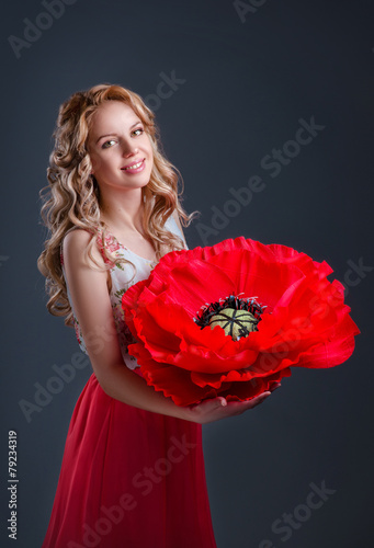 The smiling blonde girl with huge poppy-flower in her hands.