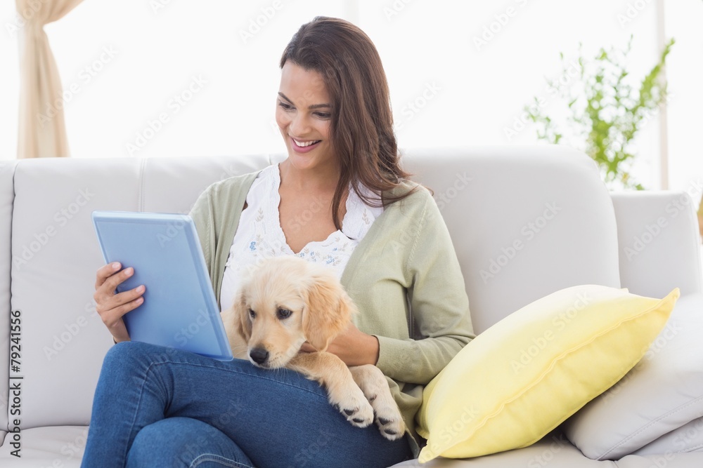 Beautiful woman with dog using digital tablet on sofa Beautiful woman with dog using digital tablet on sofa