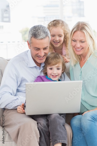 Family of four using laptop