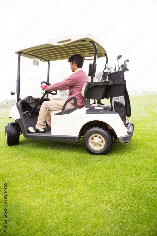 Golfer driving in his golf buggy