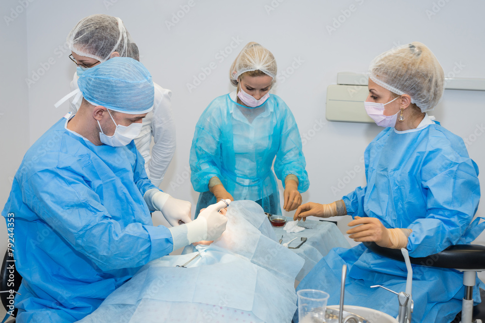 Dentists during surgery for implant placement Dentists during surgery for implant placement