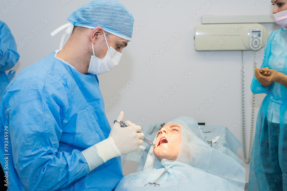 Dentists during surgery for implant placement Dentists during surgery for implant placement