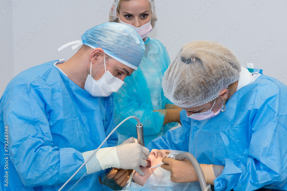 Dentists during surgery for implant placement Dentists during surgery for implant placement