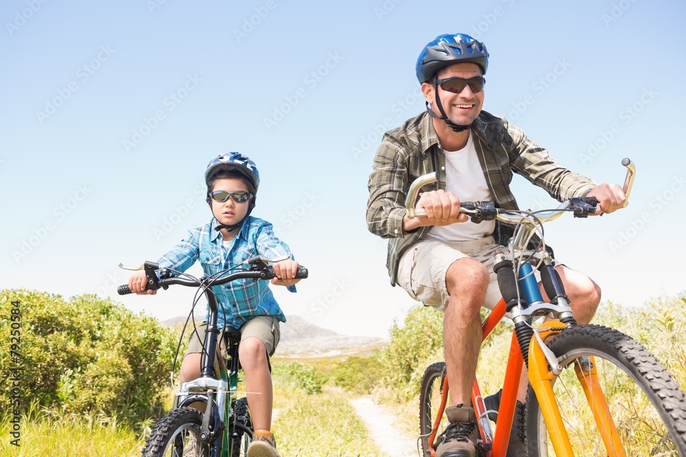 Father and son biking through mountains Father and son biking through mountains