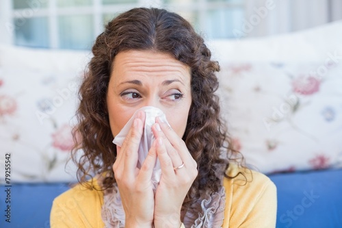 Sick woman blowing her nose