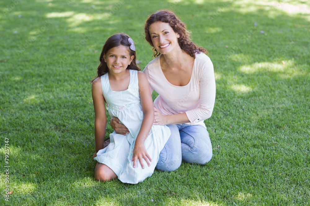 Happy mother and daughter sitting on the grass Happy mother and daughter sitting on the grass