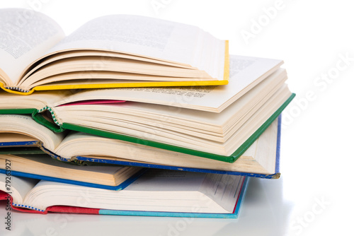 A stack of colorful, open books on a white background