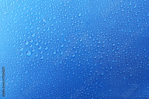Water drops on glass on blue background