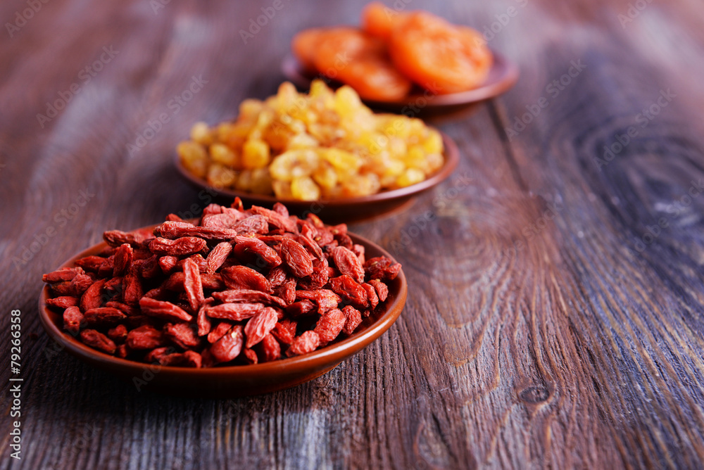 Dried fruits in small plates on rustic wooden table background Dried fruits in small plates on rustic wooden table background