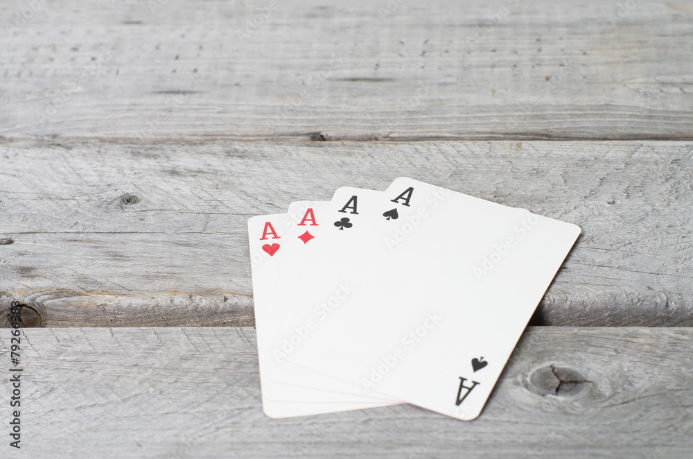 Four aces against wooden background