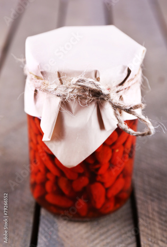 Goji berries in glass bottle wrapped with paper