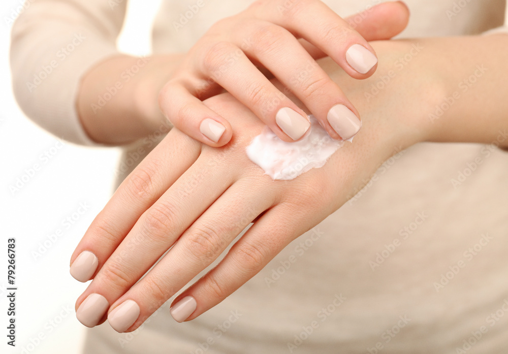 Female applying cream on her hand, closeup