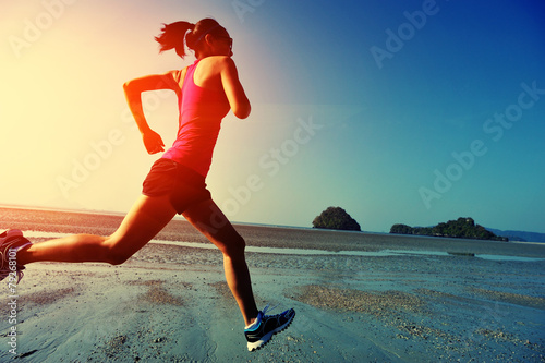 Fotografiet young woman running on sunrise beach