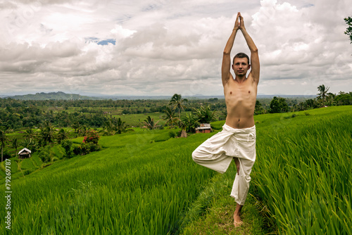 Man practicing yoga on the rice fields