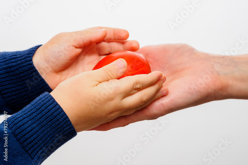 Kid hand holding red easter egg