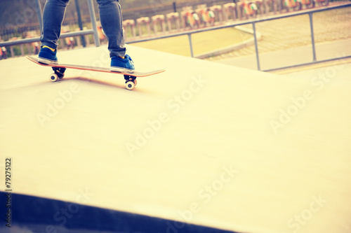 skateboarder legs skateboarding at skatepark ramp 