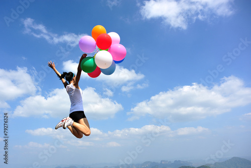  young asian woman mountain peak with colored balloons 