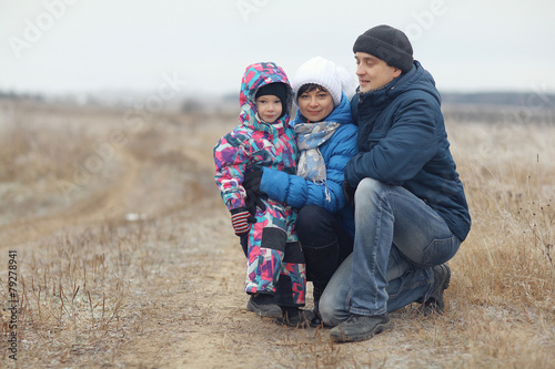 young family with a child playing on winter field