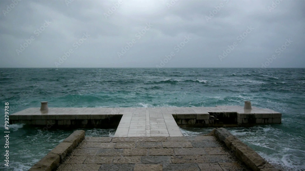 Rough weather at sea and waves crashing to the stone pier Rough weather at sea and waves crashing to the stone pier
